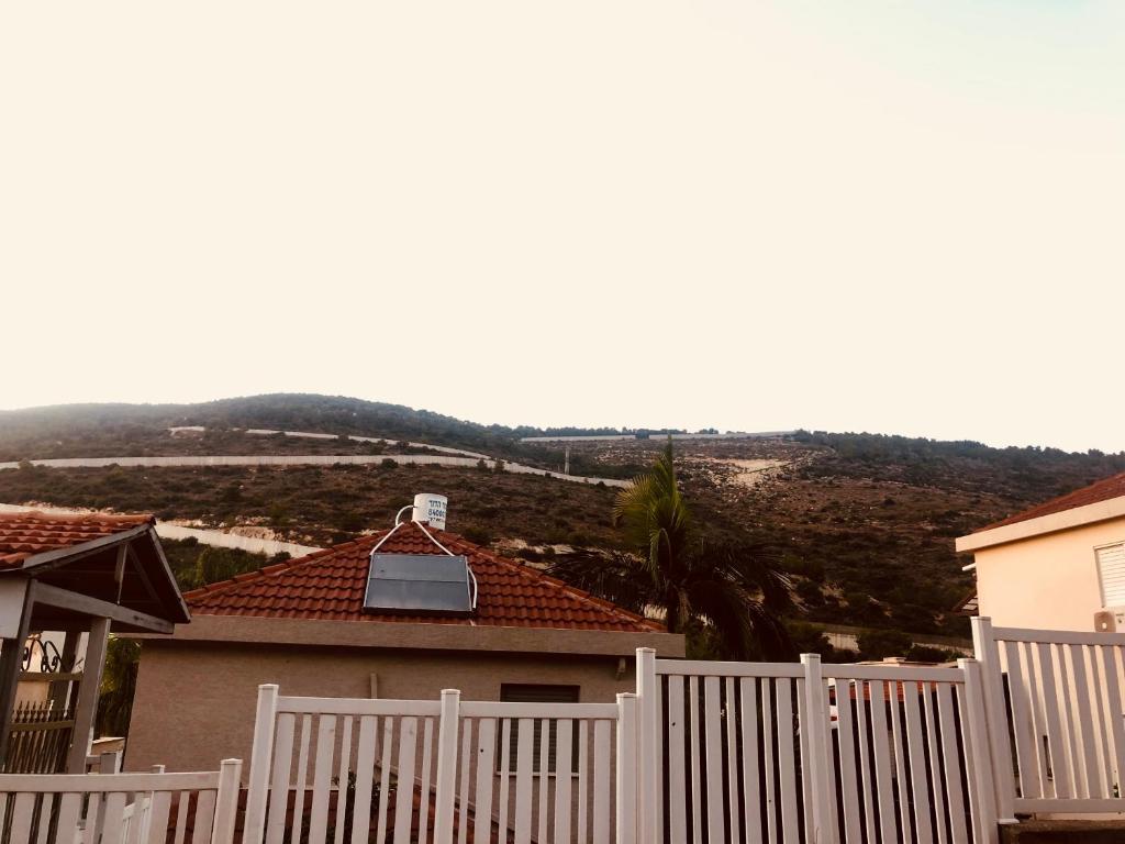 a white fence in front of a house at במורד ההר in Shelomi