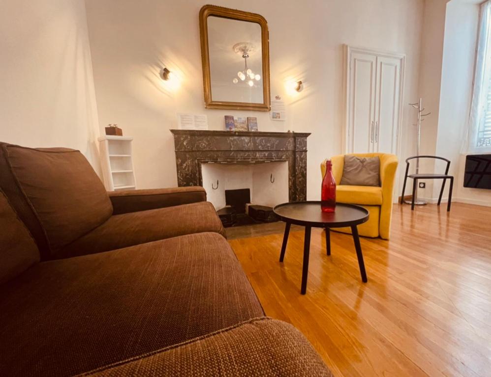 a living room with a couch and a table and a fireplace at Le Payan in Gap