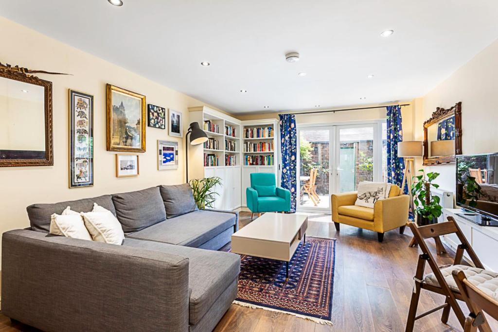 a living room with a couch and chairs in it at Terraced Bermondsey House in London