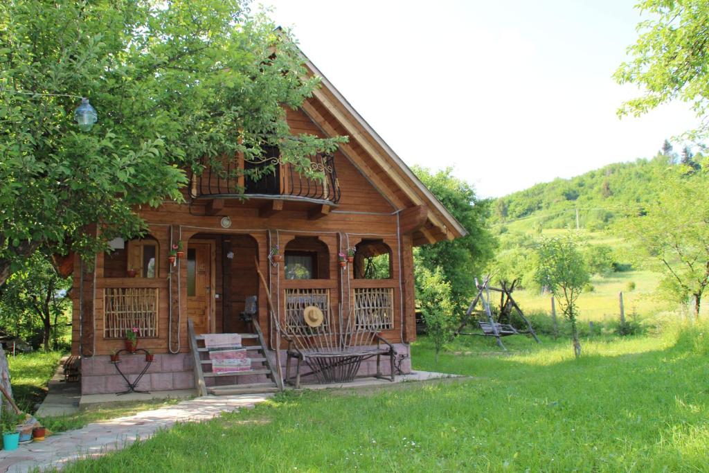 eine kleine Holzhütte mit einer Veranda und einem Balkon in der Unterkunft Saduba Kozatska Detsa in Schdenijewo