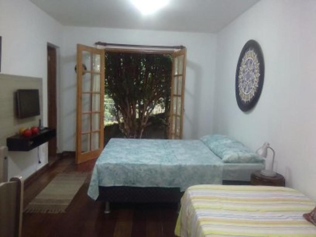 1 dormitorio con 2 camas y ventana en Loft da Montanha (A 8min do centro), en Nova Friburgo
