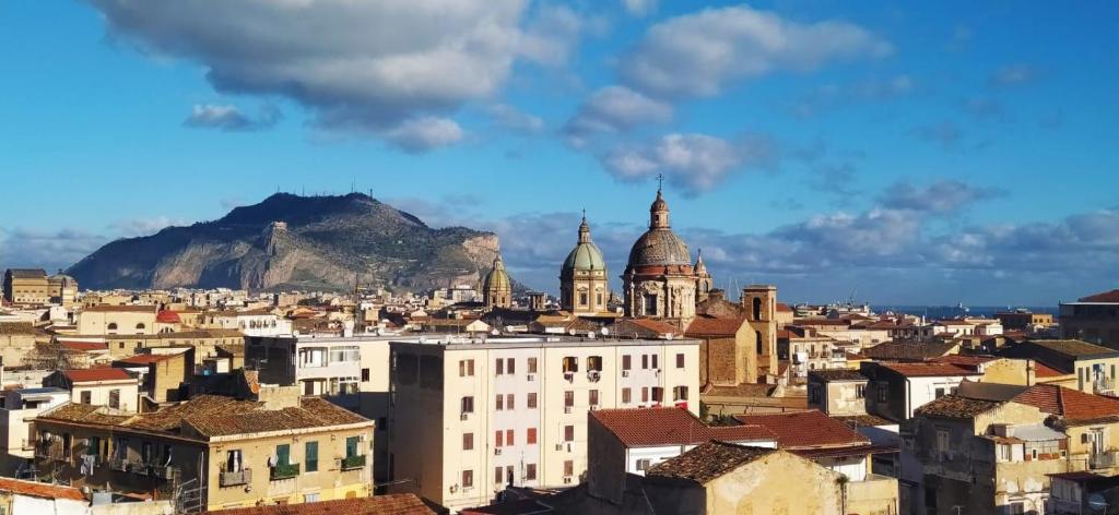 Blick auf eine Stadt mit einem Berg im Hintergrund in der Unterkunft Cocciu D’amuri in Palermo