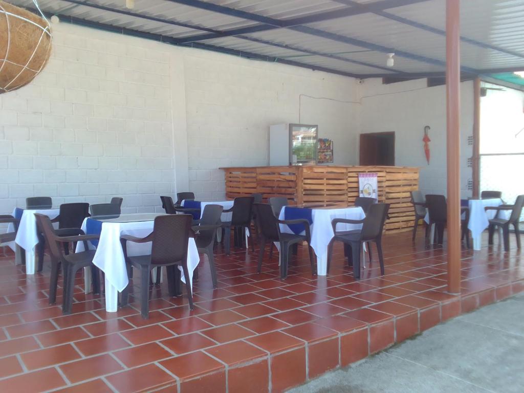 een kamer met tafels en stoelen met blauwe en witte tafelkleden bij Hotel La Casona in Chinácota