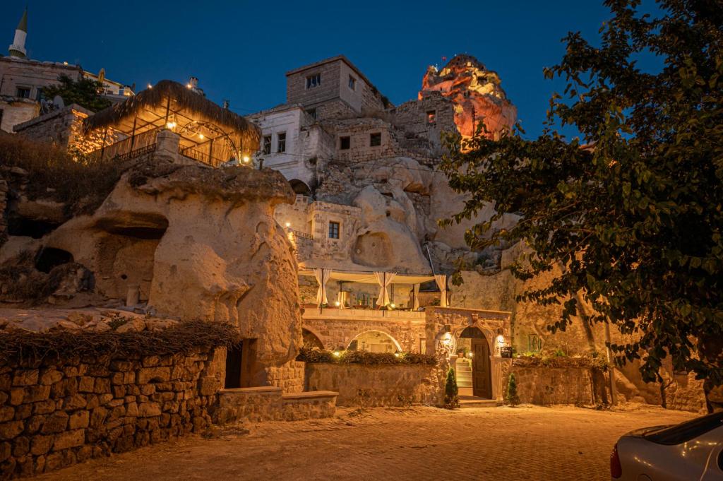 a building with lights on a mountain at night at Shiraz Cave Cappadocia in Urgup