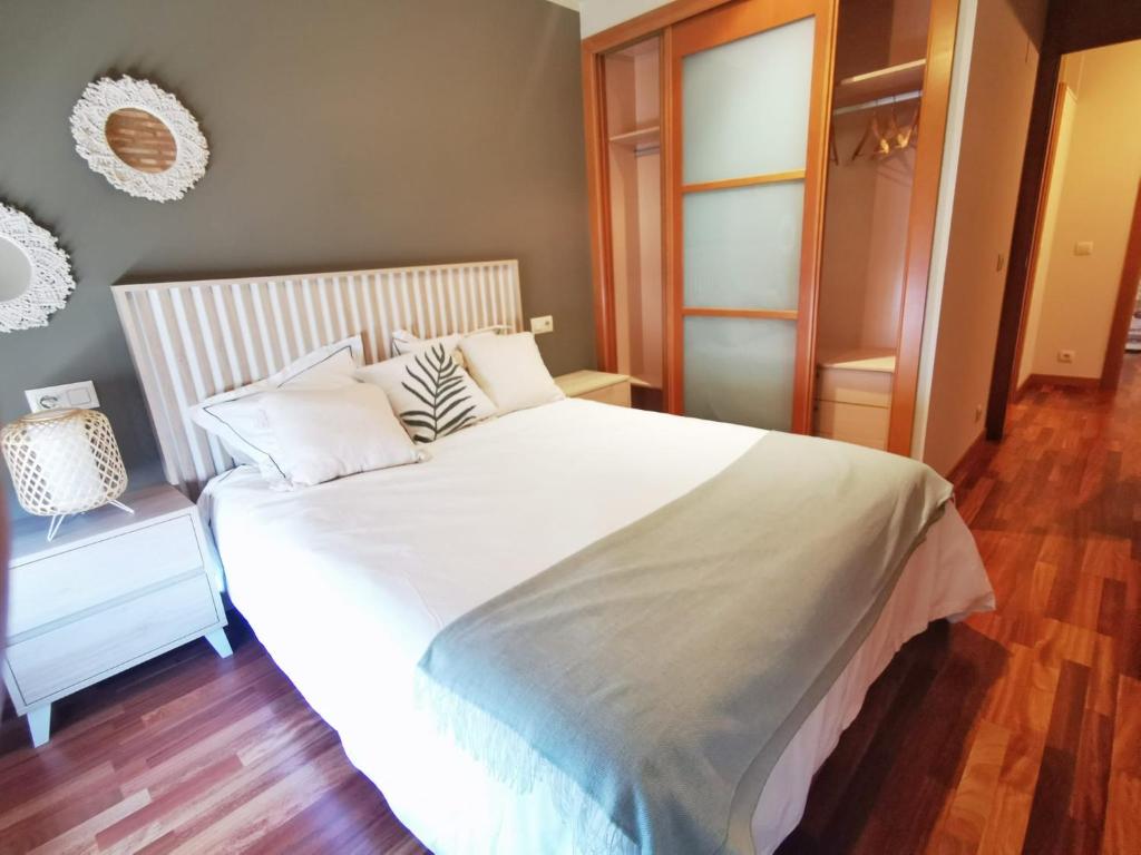 a bedroom with a large white bed and a wooden floor at AIRES DO MIÑO in Salvatierra de Miño
