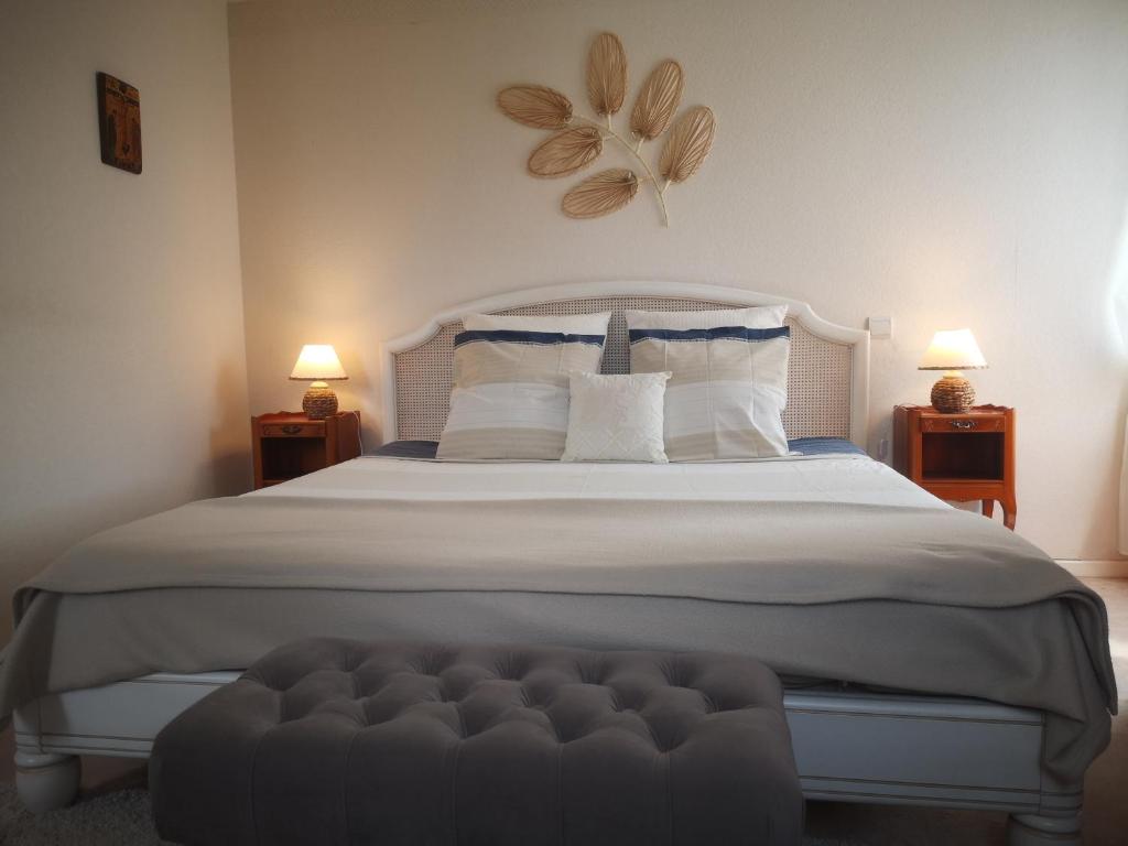 a bedroom with a large bed with a flower on the wall at Le Mimat - Jardin - Wifi - Parking in Mende