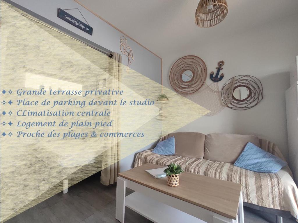 een woonkamer met een bank en een tafel bij MARSEILLAN-PLAGE - Studio climatisé avec coin nuit séparé - Terrasse & parking privé in Marseillan