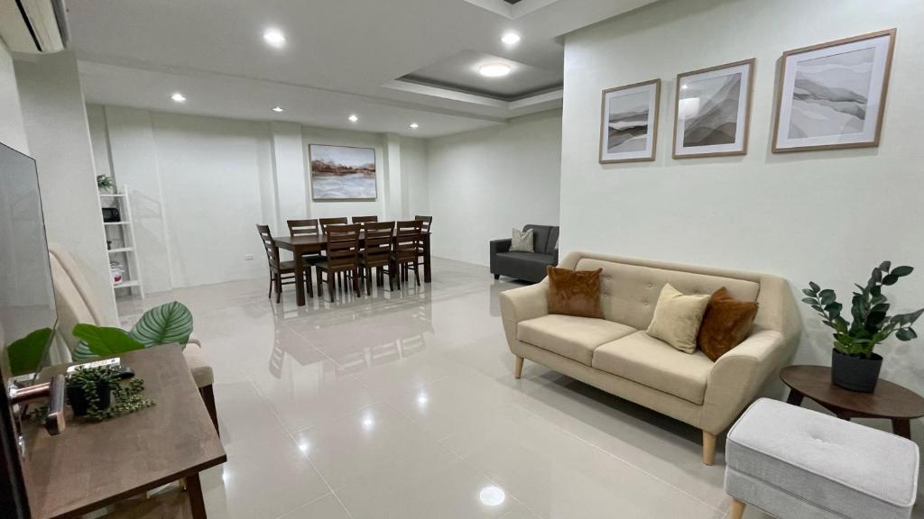 ein Wohnzimmer mit einem Sofa und einem Esszimmer in der Unterkunft New Cozy 3 Bedroom House in Davao City