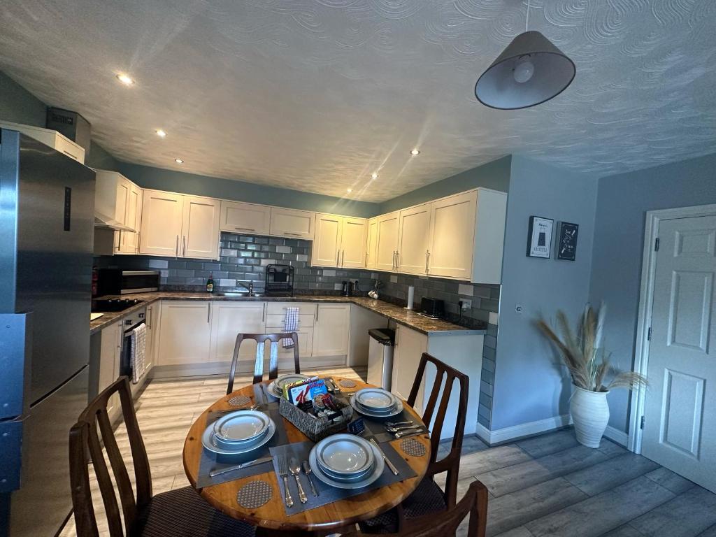 uma cozinha com uma mesa de madeira com cadeiras e uma sala de jantar em Entire 2 bedroom house. em Rowley Regis