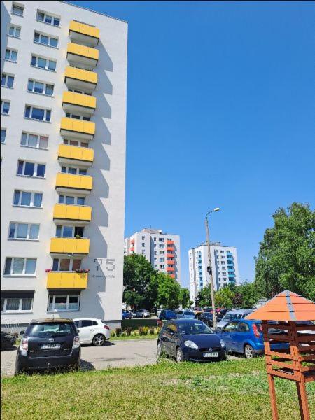 a parking lot with cars parked in front of a building at Apartament na Słoneczników in Tarnowskie Góry
