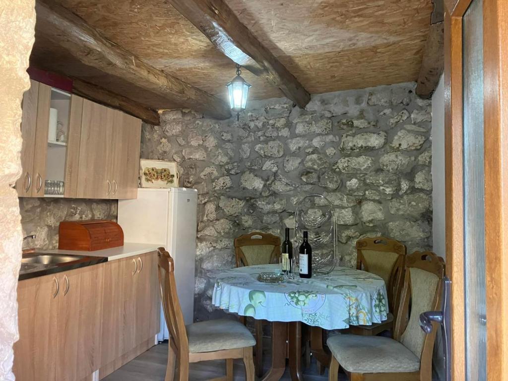 uma cozinha com uma mesa com garrafas de vinho em Stone house em Cetinje