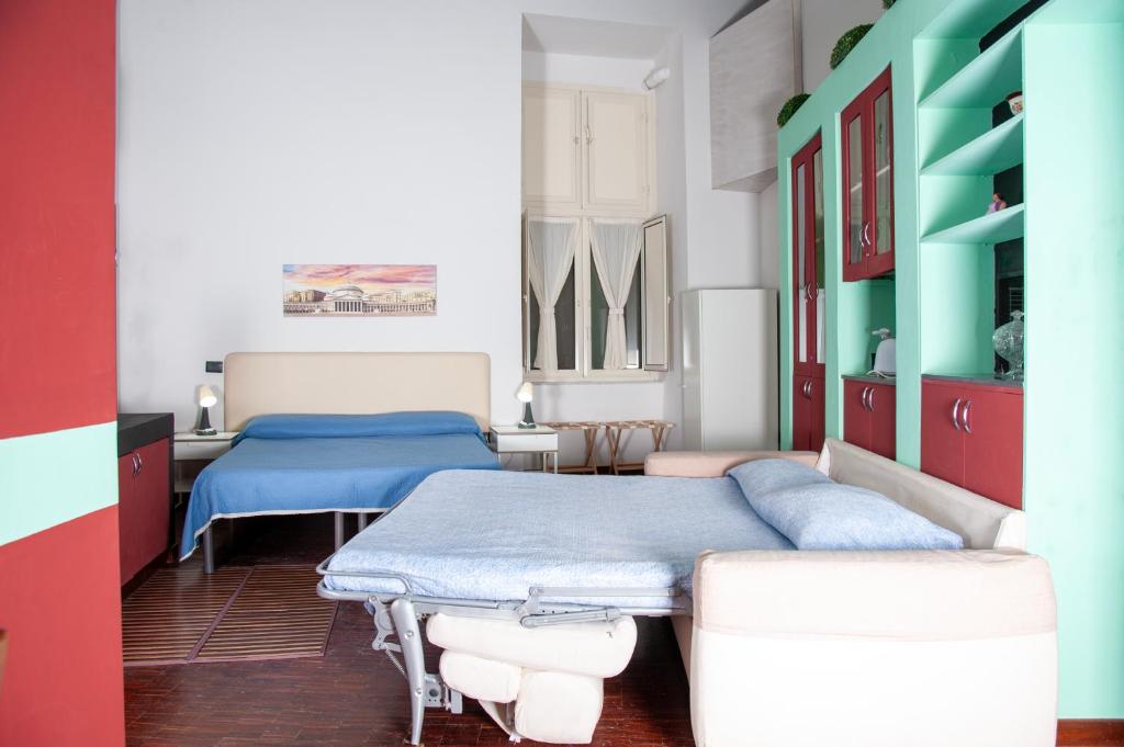 ナポリにあるPalazzo Carafa della Spina - Maison de Charmeのベッド2台 赤と青の部屋