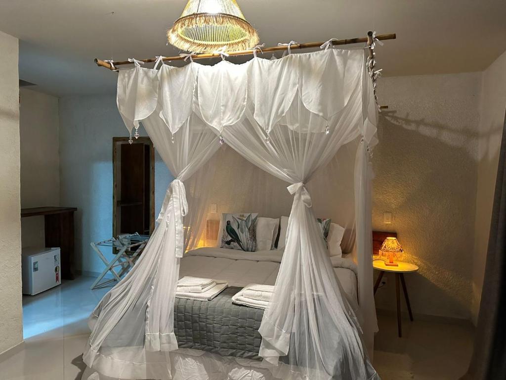 um quarto com uma cama de dossel em Pousada Preciosa do Arraial - com Natura e L'Occitane -inaugurada há 1 ano em Arraial d'Ajuda