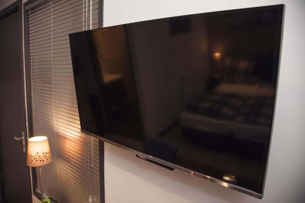uma televisão de ecrã plano pendurada numa parede em Appartement Droste em Haarlem
