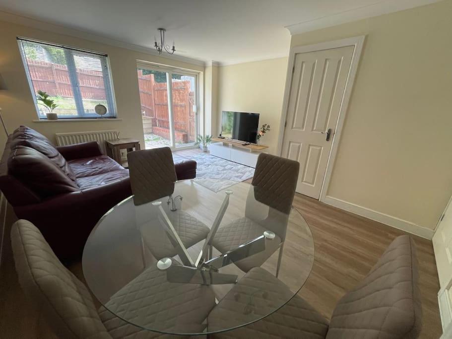 Una sala de estar con una mesa de cristal y un sofá. en Imperial way Ashford TN23, en Kent
