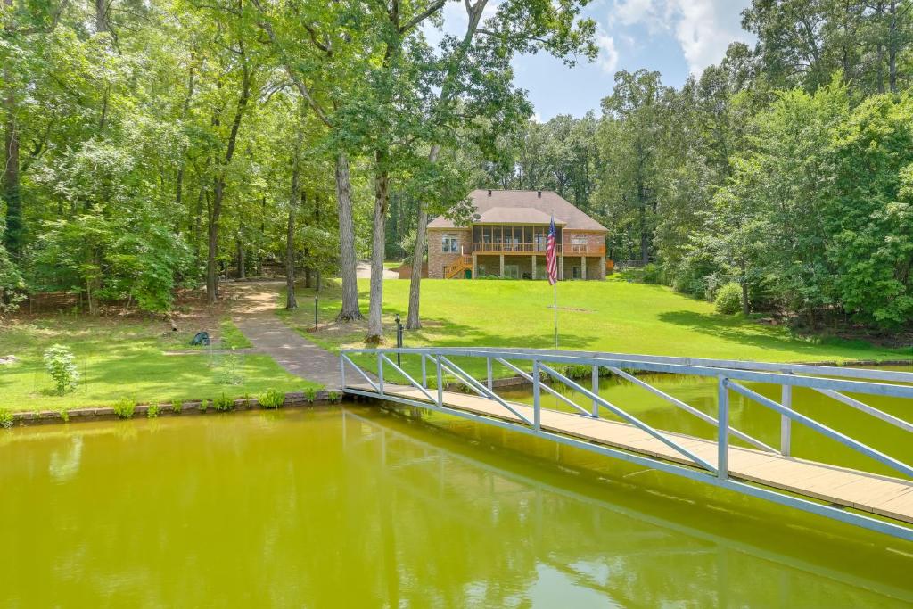 un pont sur une rivière avec une maison en arrière-plan dans l'établissement Sunny Coosa River Hideaway with Boat Dock and Slip!, 