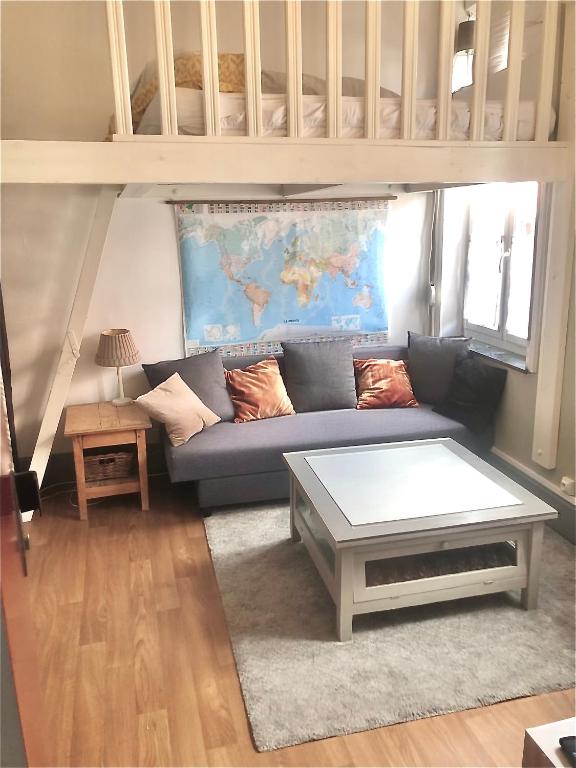 un salon avec un canapé bleu et une table dans l'établissement Cocon avec cour citadelle Vauban, à Lille