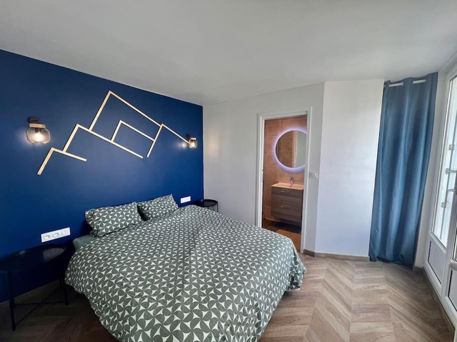 une chambre avec un lit et un mur bleu dans l'établissement Appartement T2 proche des prébendes, à Tours