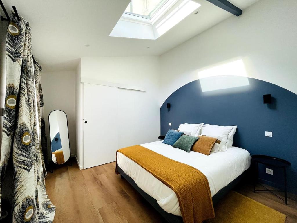 une chambre avec un grand lit avec un mur bleu dans l'établissement Loft - Centre Ville, à Brest