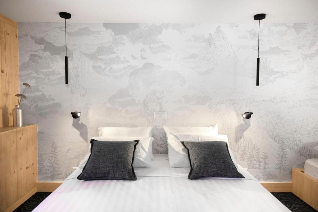 a white bed with two pillows in a bedroom at Miroir d'Argentine in Gryon