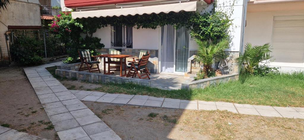 a patio with a table and chairs in front of a house at Pefkochori Family Spot in Pefkohori