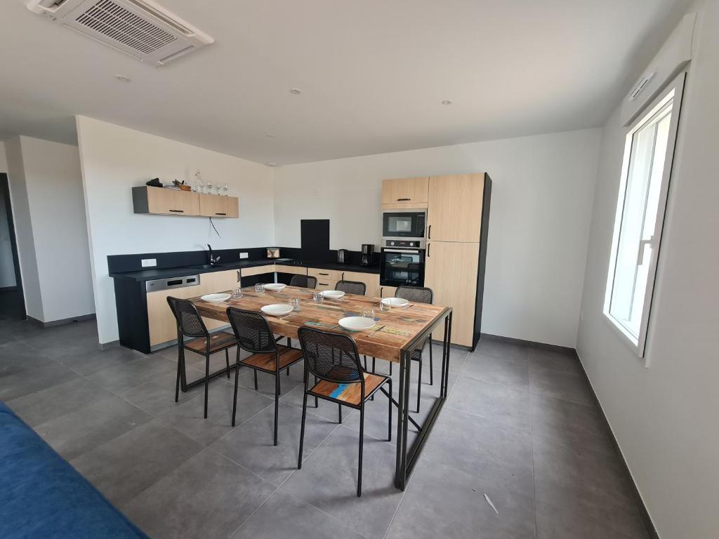 une cuisine avec une table et des chaises dans une pièce dans l'établissement Gîtes du Grand Air, à Saint-Michel-en-lʼHerm