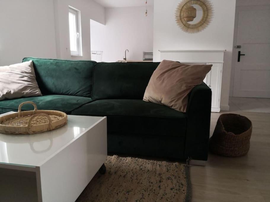 salon z zieloną kanapą i białym stołem w obiekcie Przestronne blisko jezior w mieście Osowiec Śląski