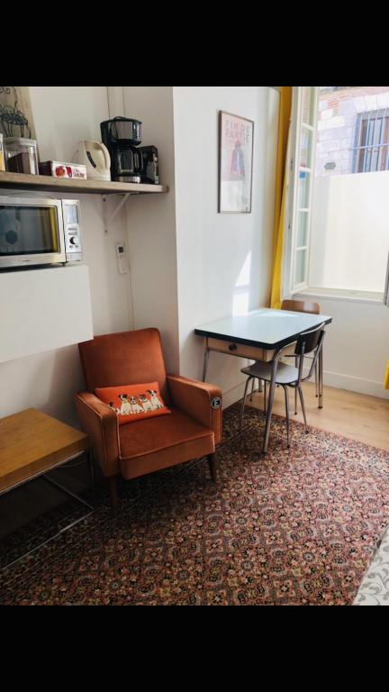 - un salon avec une table, un canapé, une table et une chaise dans l'établissement Bulles Champagne Troyes Bouchon, à Troyes