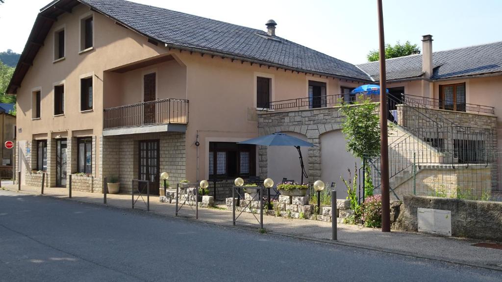 a house with an umbrella on the side of the street at Au Pont de la Ginéze in Barjac