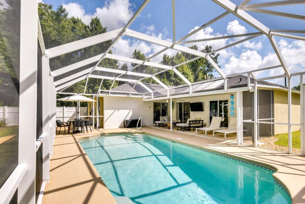 a house with a swimming pool with a glass roof at Beach Gear and Fire Pit Palm Coast Group Escape in Palm Coast