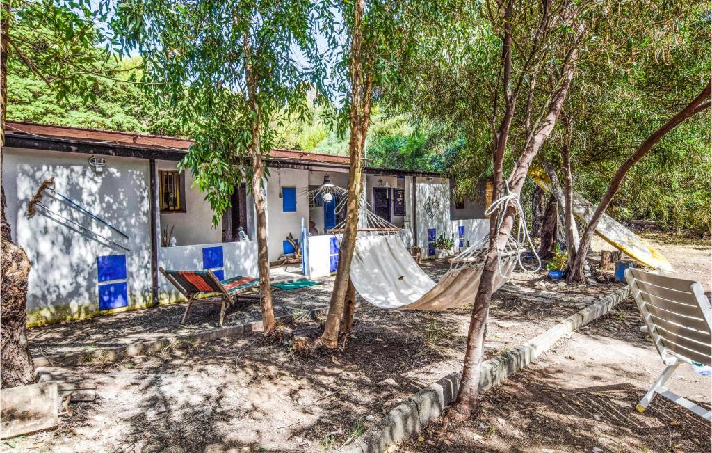 - un hamac à l'ombre des arbres devant une maison dans l'établissement Beautiful Home In Villapiana With Wifi, à Villapiana