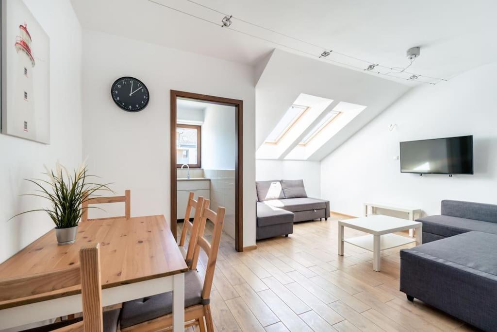 una sala de estar con una mesa y un sofá en Apartament Mierzeja Wiślana, en Sztutowo