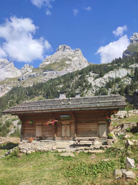 a small cabin in the mountains with mountains in the background at La petite Anfiane in Le Grand-Bornand