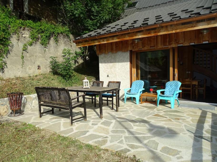 a patio with a table and chairs on a stone patio at Apartment Belledonne 3 minutes from Alpe d Huez Grand Domaine via Oz en Oisans in Oz