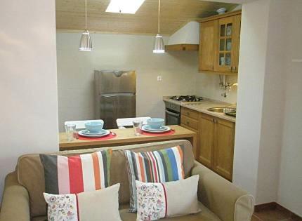 eine Küche mit einem Sofa mit Kissen und einer Küchentheke in der Unterkunft Casa Azenhas in Azenhas do Mar