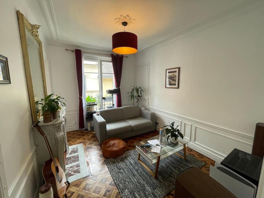 un salon avec un canapé et une table dans l'établissement L'authentique vie parisienne, à Paris