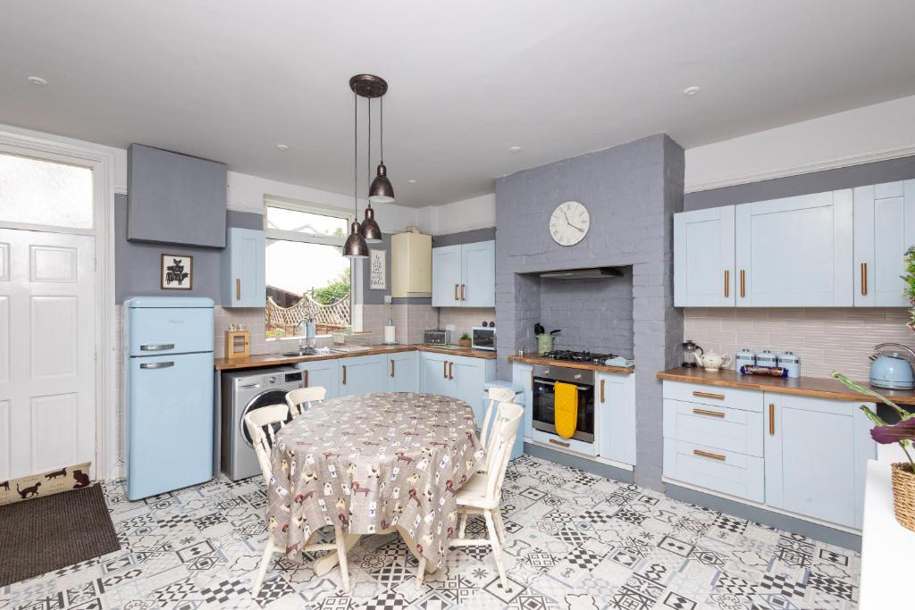 a kitchen with a table and a kitchen with white cabinets at Horbury High St Wakefield in Horbury