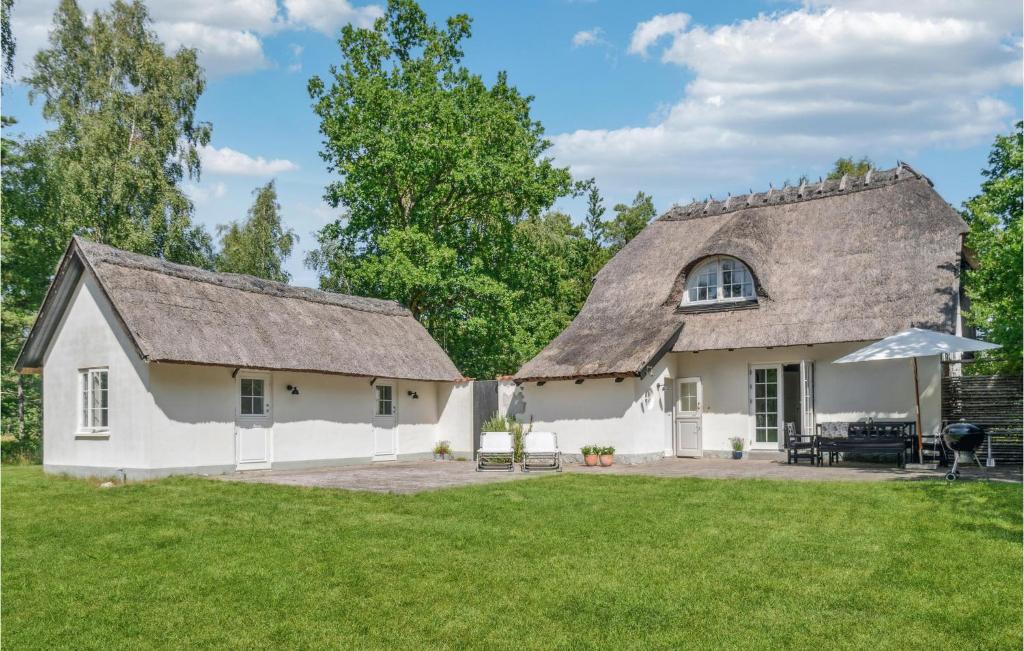 una grande casa bianca con tetto di paglia di Beautiful Home In Rrvig With Kitchen a Rørvig
