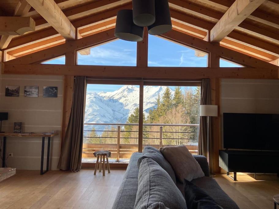 a living room with a couch and a large window at Les Arcs - Chalet Arc Ô Mont in Arc 1600