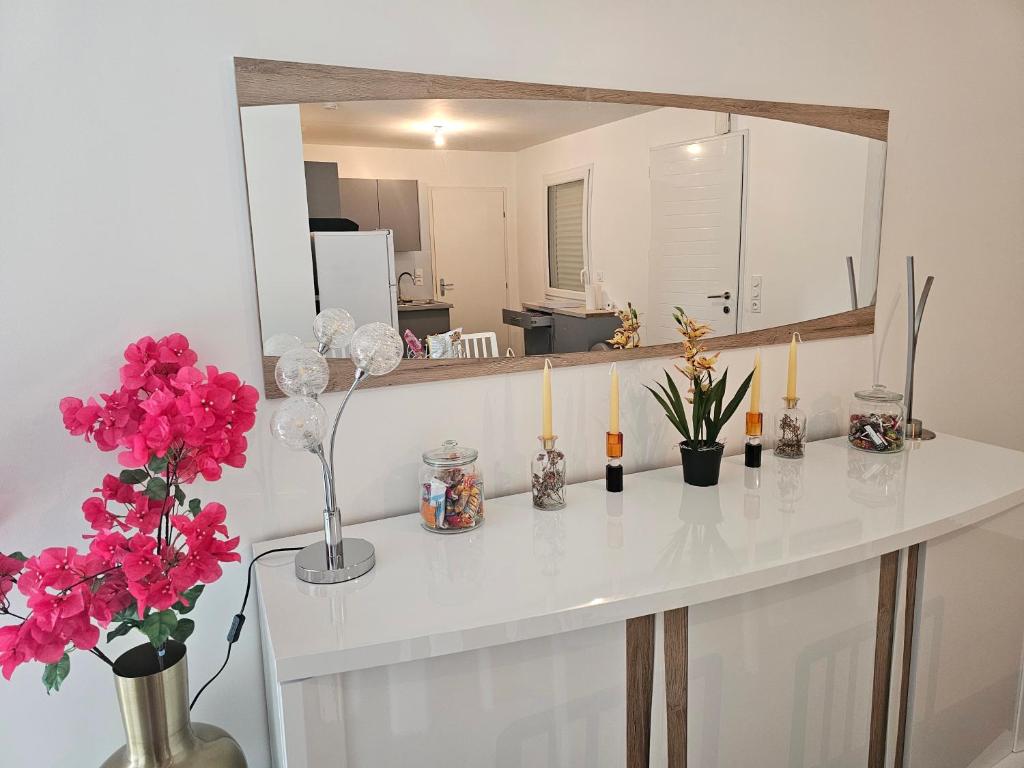 プロムールにあるMaison accès PMR PERSONNE A MOBILITE REDUITE sur Ploemeur proche Lorientの白いカウンターと花とキャンドルが備わるお部屋