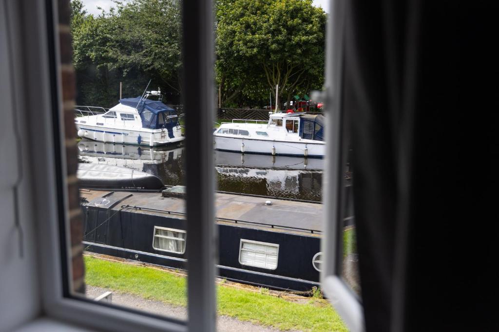 uma vista de uma janela de barcos na água em Canal Side Cottage Wakefield em Stanley