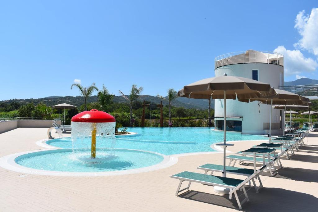 una piscina con sillas y una bola roja en el agua en Hyele Accommodation Experience, en Casal Velino