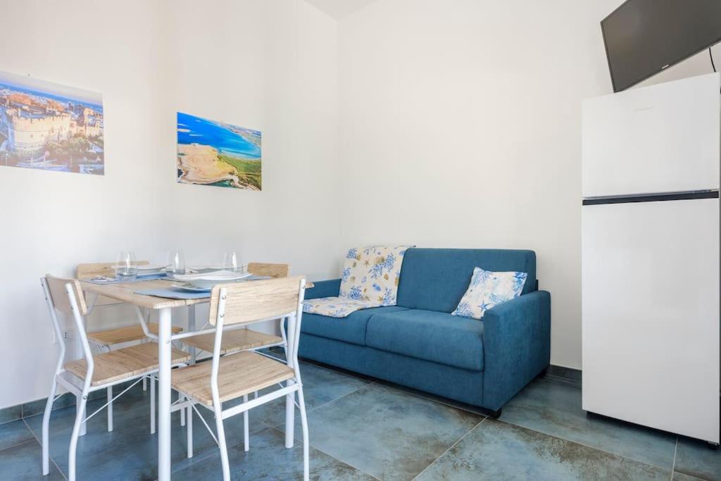 un salon avec un canapé bleu et une table dans l'établissement La Casa degli Oleandri, à Torre Santa Sabina