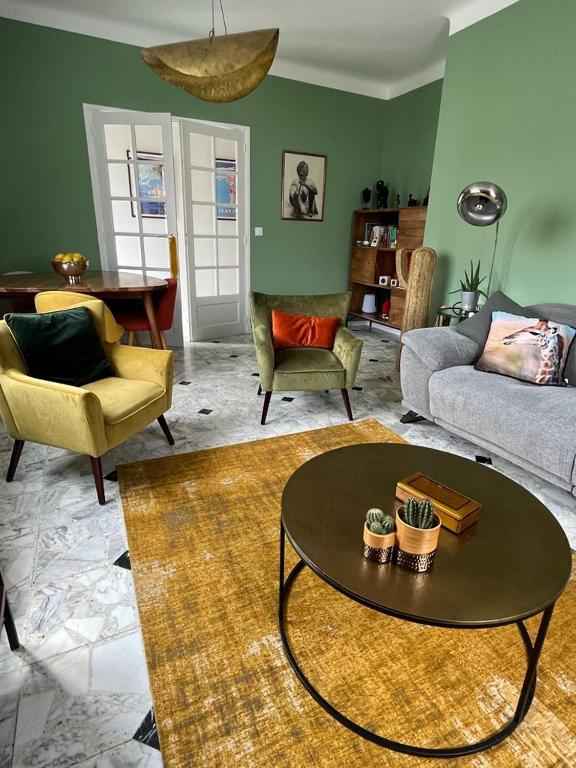 un salon avec un canapé, une table et des chaises dans l'établissement Maison de charme avec jardin, à Carcassonne