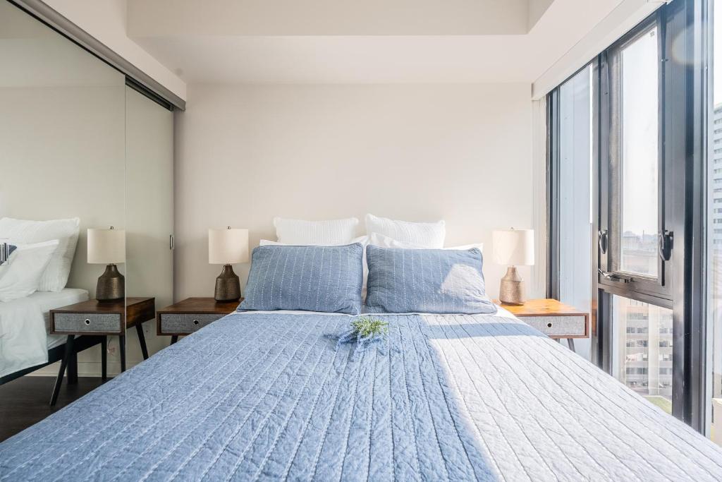 a bedroom with a large bed with blue pillows at Traveller home in centre Toronto in Toronto