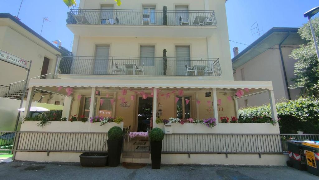 ein Gebäude mit einem Balkon mit Blumen darauf in der Unterkunft Hotel Eriale in Rimini