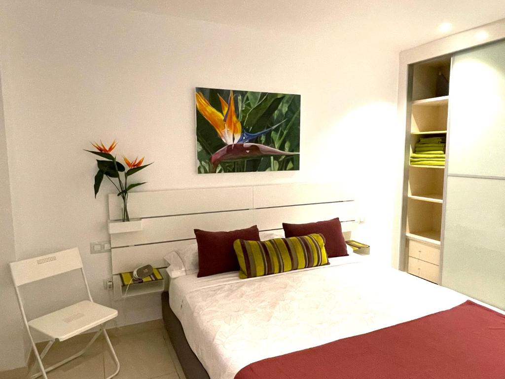 een slaapkamer met een bed en een schilderij aan de muur bij Casa Las Olas in Palm-mar