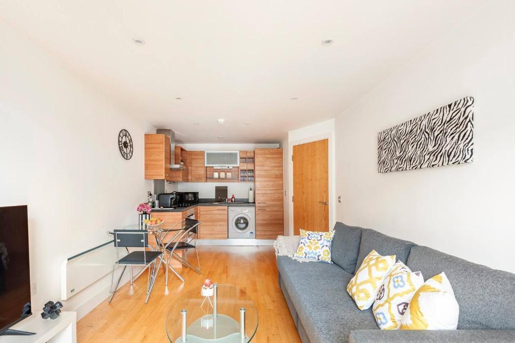 a living room with a couch and a kitchen at Cozy Apt Near Central Leeds in Hunslet