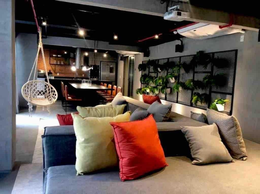 a living room with a couch with colorful pillows at RioDowntown - Rede Nosso Cantinho in Rio de Janeiro