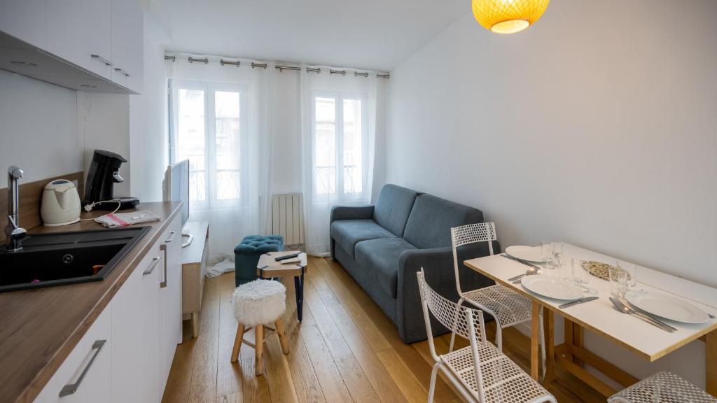 a living room with a blue couch and a table at La Capitale - Les Gîtes de L Argile in Barcelonnette